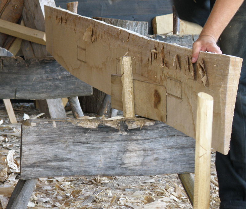 Mike the boat-builder is thinning this plank to make a strake. He has worked his way along the plank, axing into the wood to lift, but not remove, chips from the surface.