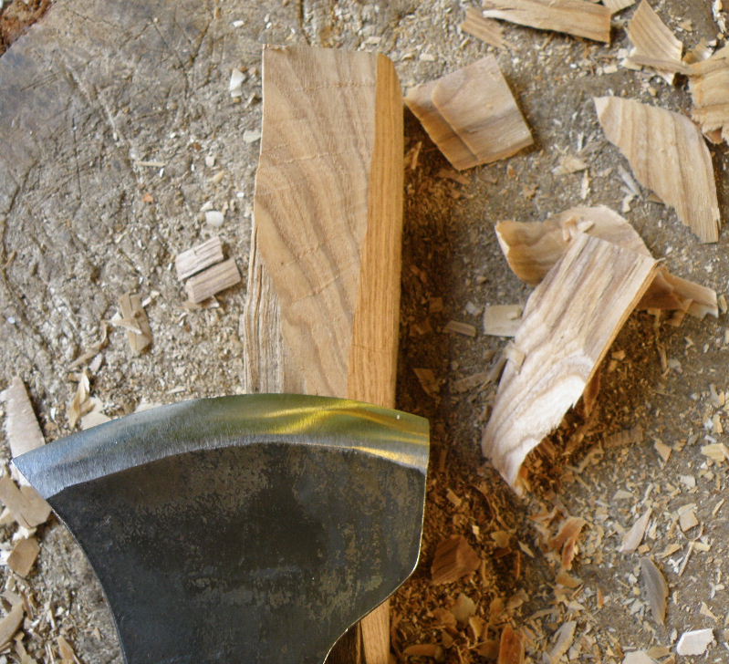 Gently curving marks on the wood surface show where the axe stopped each time, to remove the chips that are left scattered on the chopping-block.